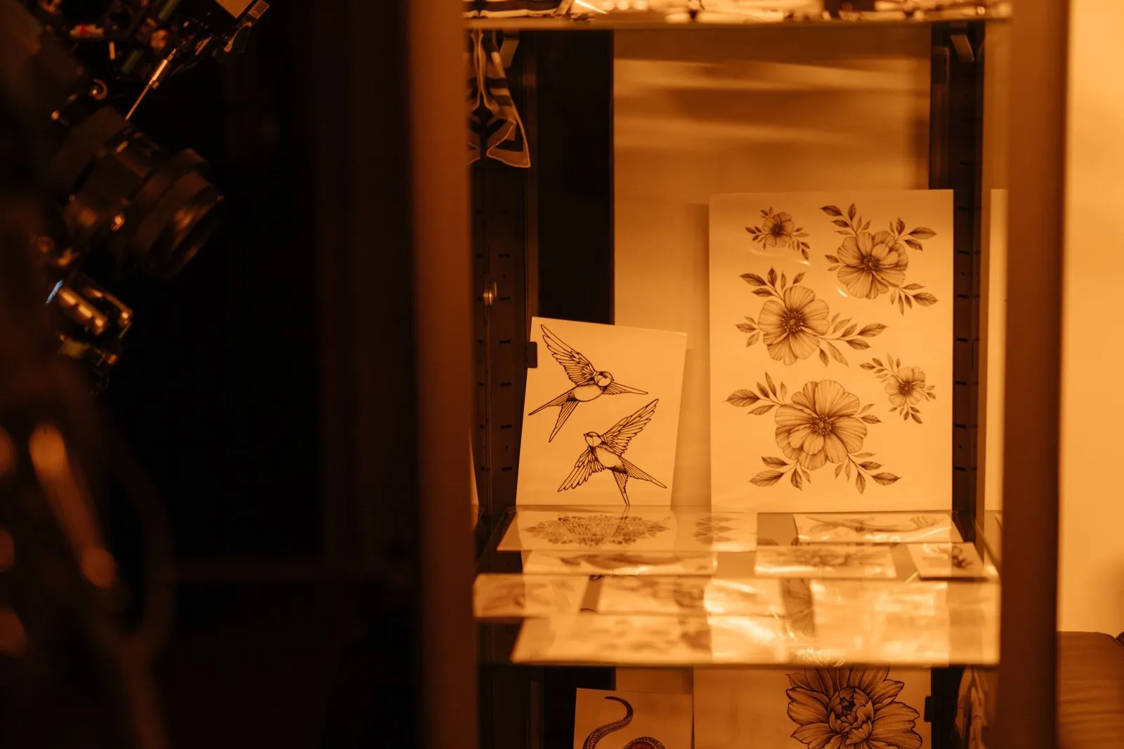 Gros plan sur un tatoueur qui estime le prix d'un tatouage devant une calculette et des croquis