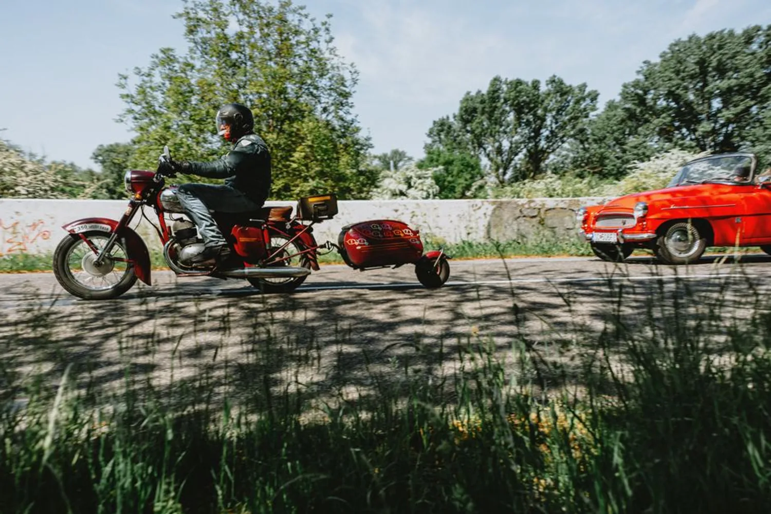 Une moto et une voiture se croisent sur une route de campagne.